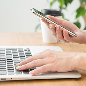 スマホやパソコンから画像加工の注文フォームを入力している人